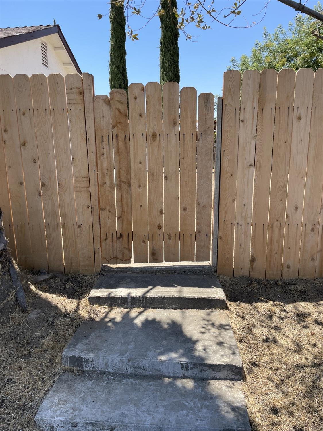605 El Monte Street Madera, CA 93637 - Photo 16 of 17 a view of a house with a wooden fence