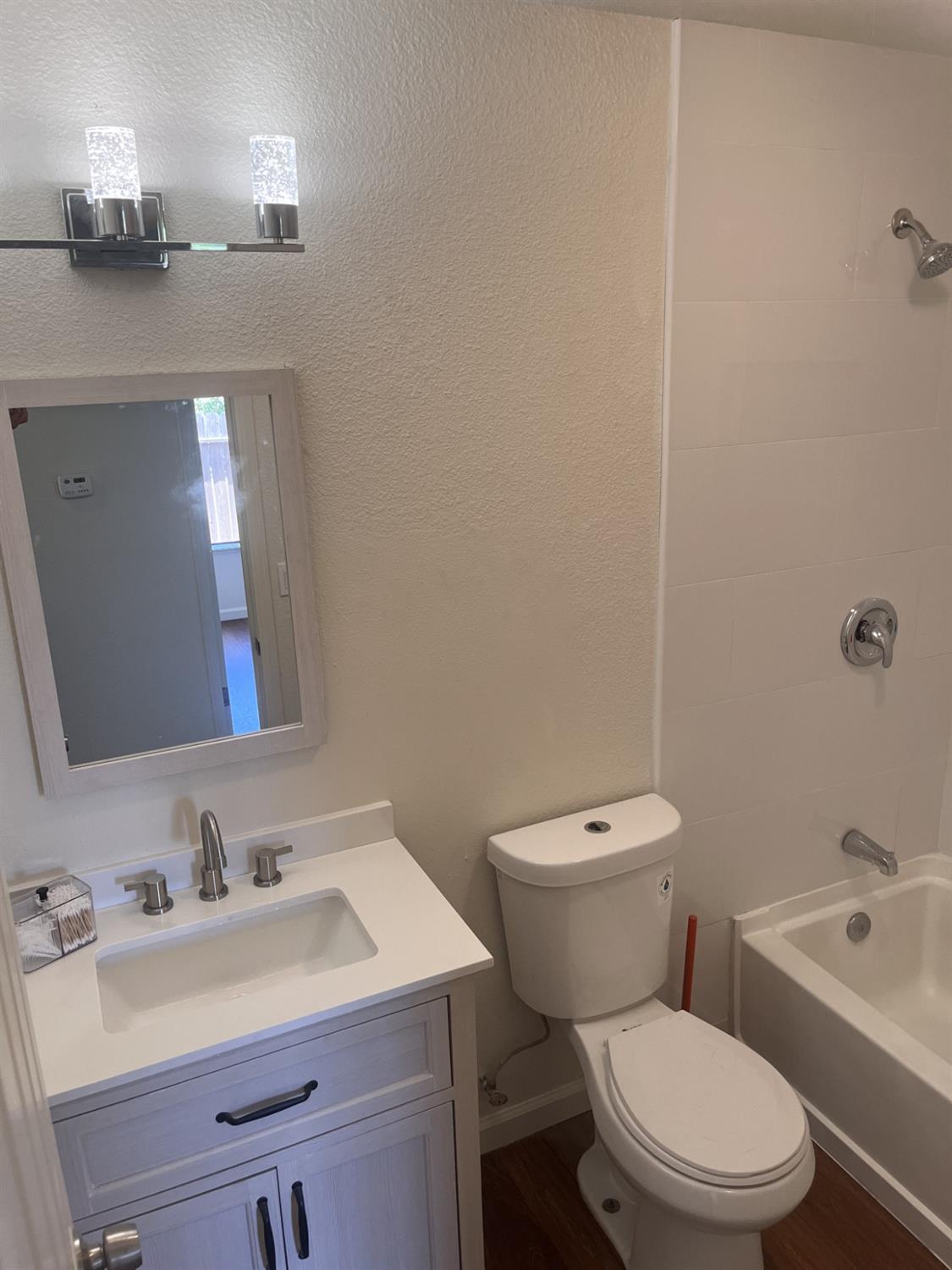 605 El Monte Street Madera, CA 93637 - Photo 5 of 17 a bathroom with a toilet a sink and mirror