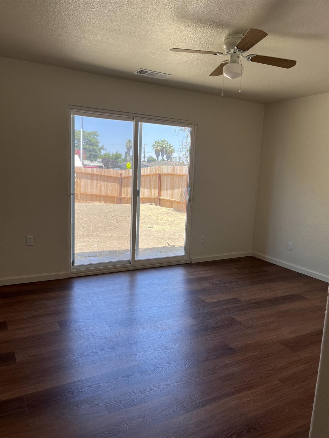605 El Monte Street Madera, CA 93637 - Photo 8 of 17 a view of empty room with wooden floor and fan