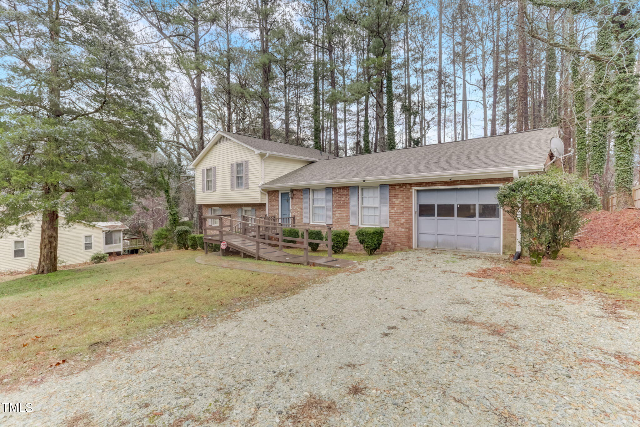 5502 Russell Road Durham, NC 27712 - Photo 2 of 31 a front view of a house with a dirt yard and a large tree