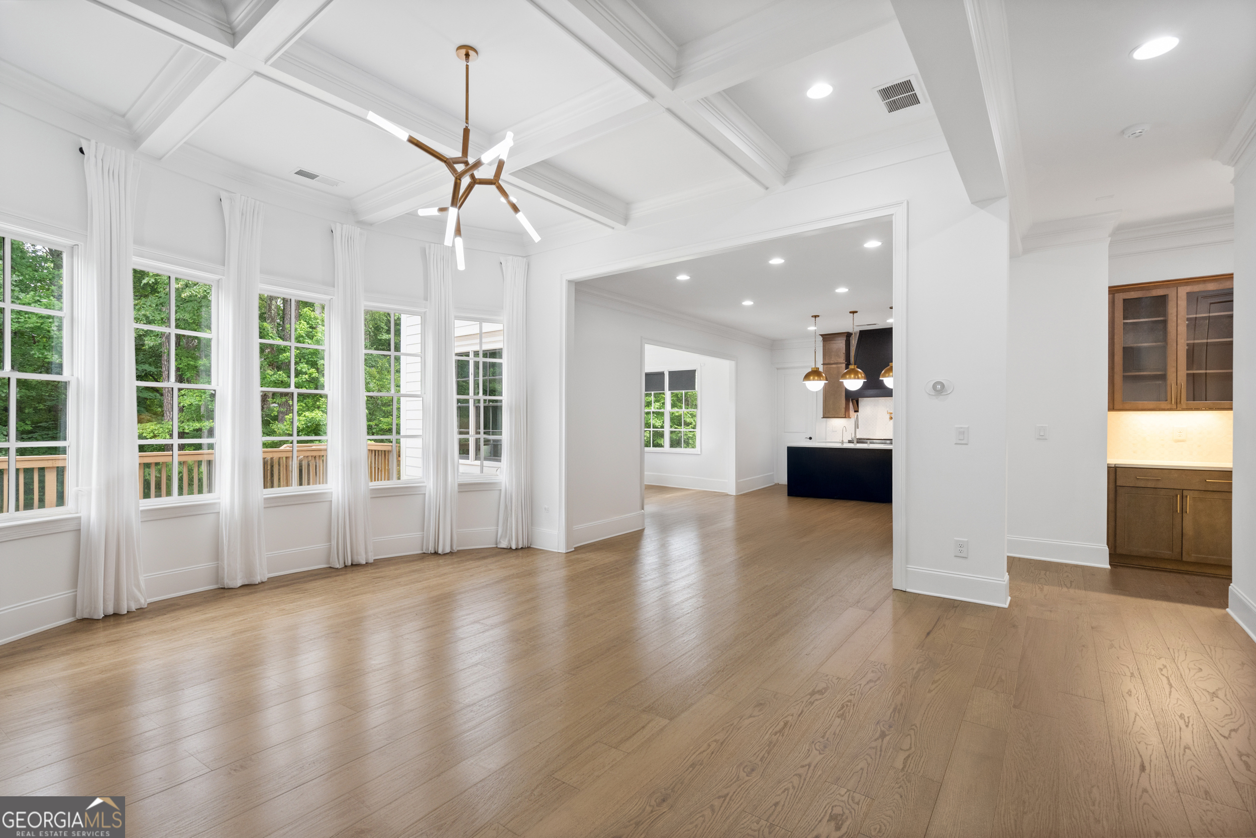 2045 Kent Court Milton, GA 30004 - Photo 38 of 104 a view of an empty room with wooden floor and a kitchen