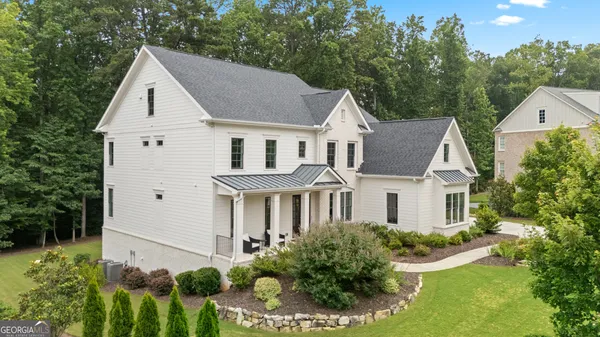 a view of white house with a yard and potted plants