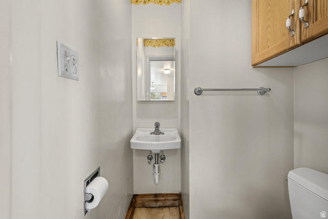 542 East 3400th Street North Provo, UT 84604 - Photo 17 of 39 Compact powder room featuring a wall-mounted sink with chrome faucet, a recessed toilet paper holder, and a wood-finish floor