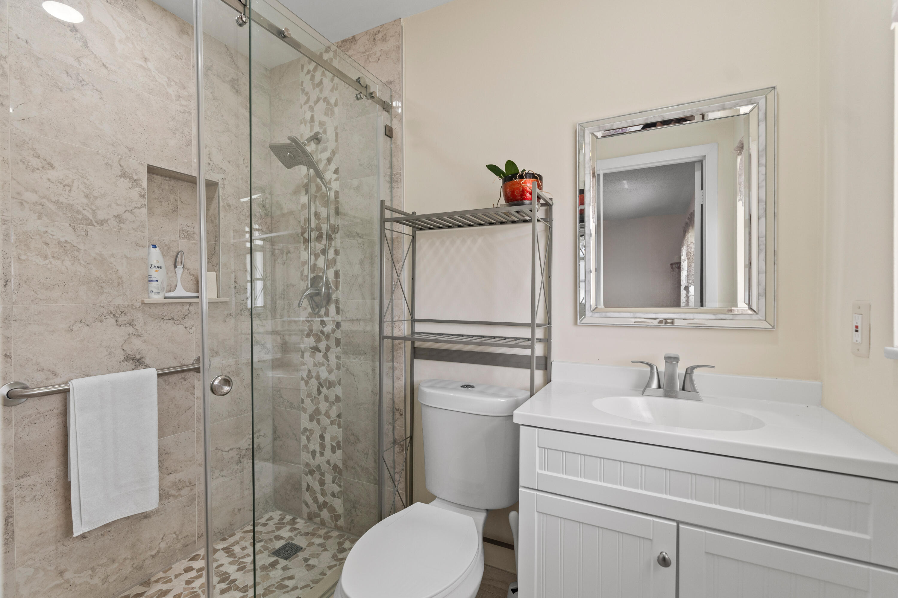 249 Cardinal Lane Delray Beach, FL 33445 - Photo 19 of 36 a bathroom with a toilet sink vanity and shower