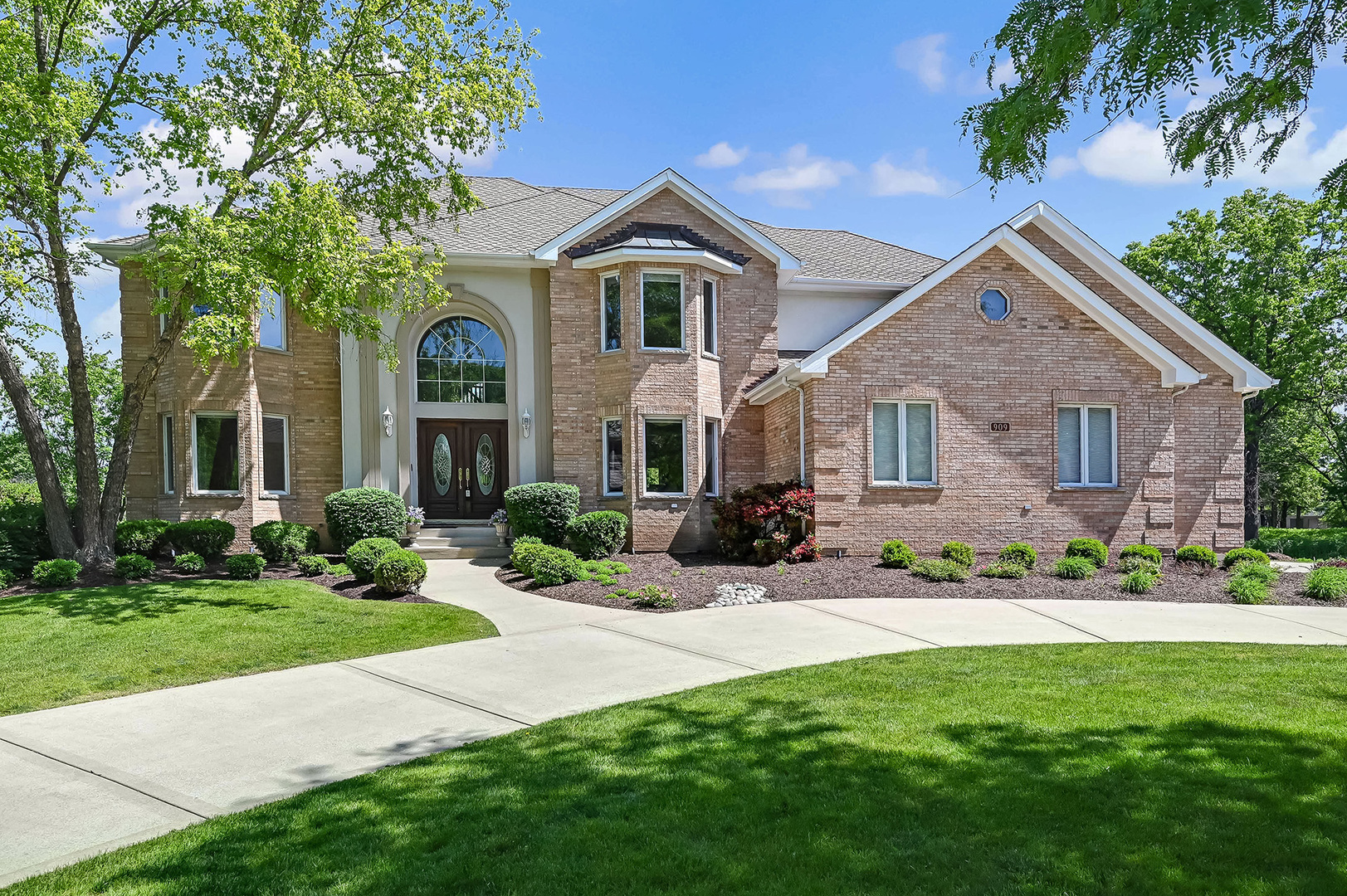 a front view of a house with a garden and yard