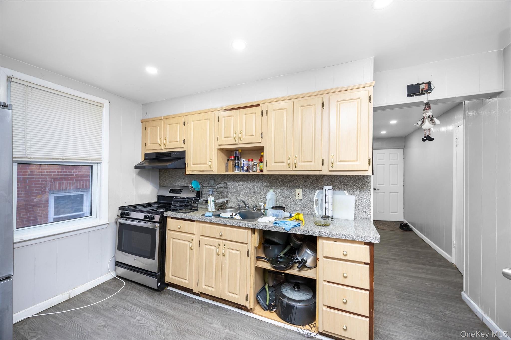 65-11 Perry Avenue Queens, NY 11378 - Photo 17 of 22 a kitchen with stainless steel appliances a stove a sink cabinets and a window