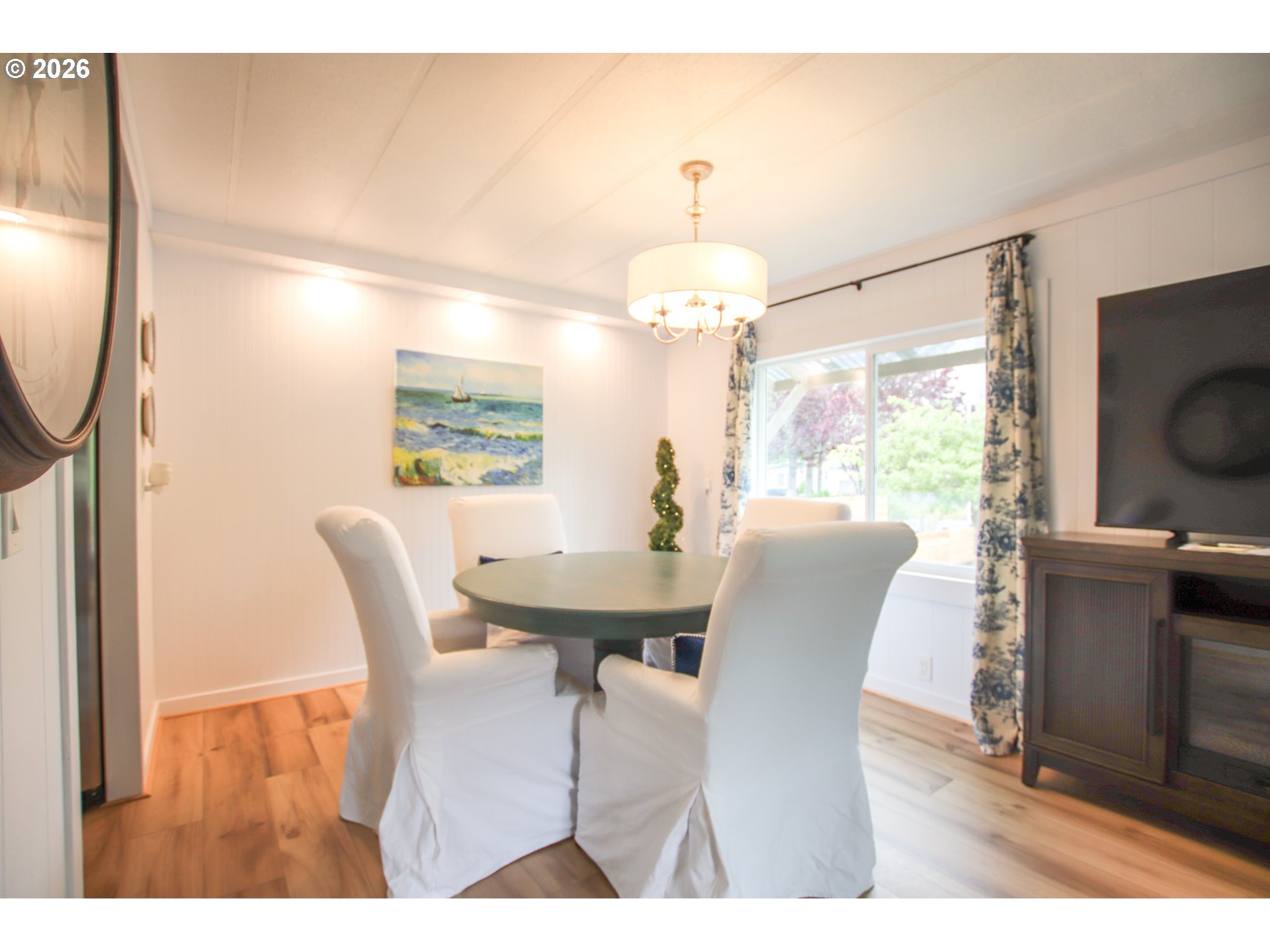 1431 Maple Street Florence, OR 97439 - Photo 11 of 43 a dining room with furniture a chandelier and wooden floor