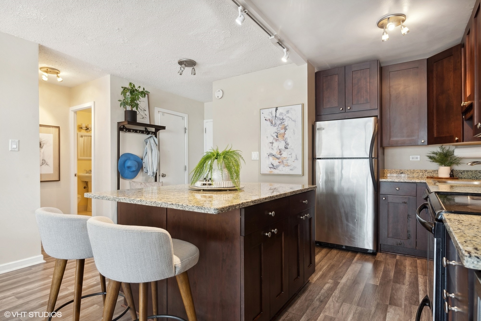 2930 North Sheridan Road, Unit 909 Chicago, IL 60657 - Photo 5 of 17 a kitchen with stainless steel appliances a dining table chairs refrigerator and sink