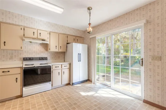 a kitchen with stainless steel appliances granite countertop a stove a refrigerator and white cabinets