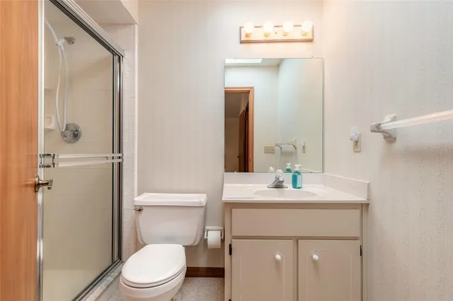 a bathroom with a sink a toilet and shower