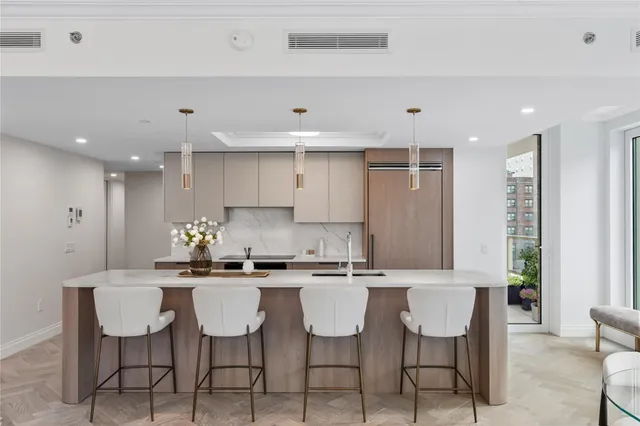 a kitchen with a dining table chairs and white cabinets