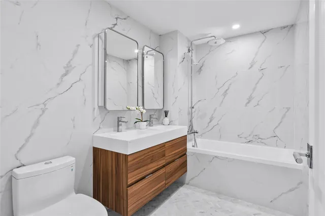 a bathroom with a sink toilet vanity and tub