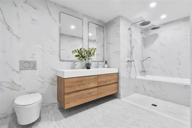 a bathroom with a sink a toilet and shower