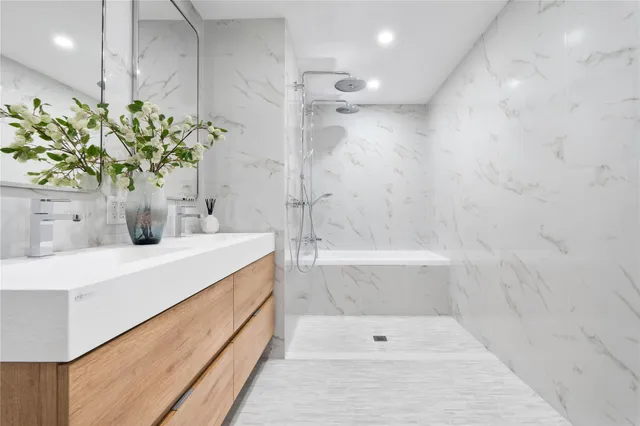 a bathroom with a sink a faucet a potted plant and a shower