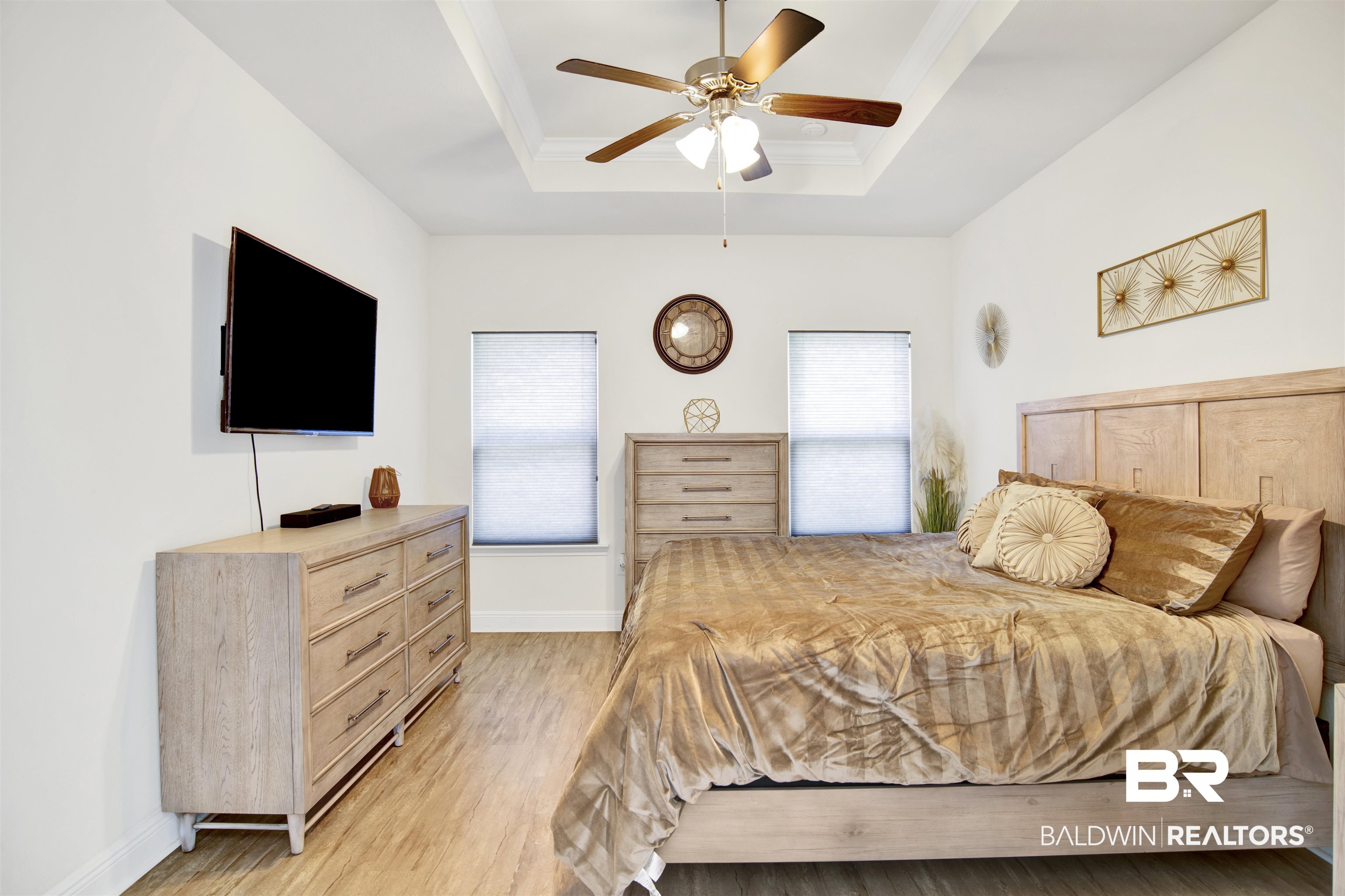 1468 Surrey Loop Foley, AL 36535 - Photo 21 of 28 Bedroom with light wood-style flooring, multiple windows, a raised ceiling, and baseboards