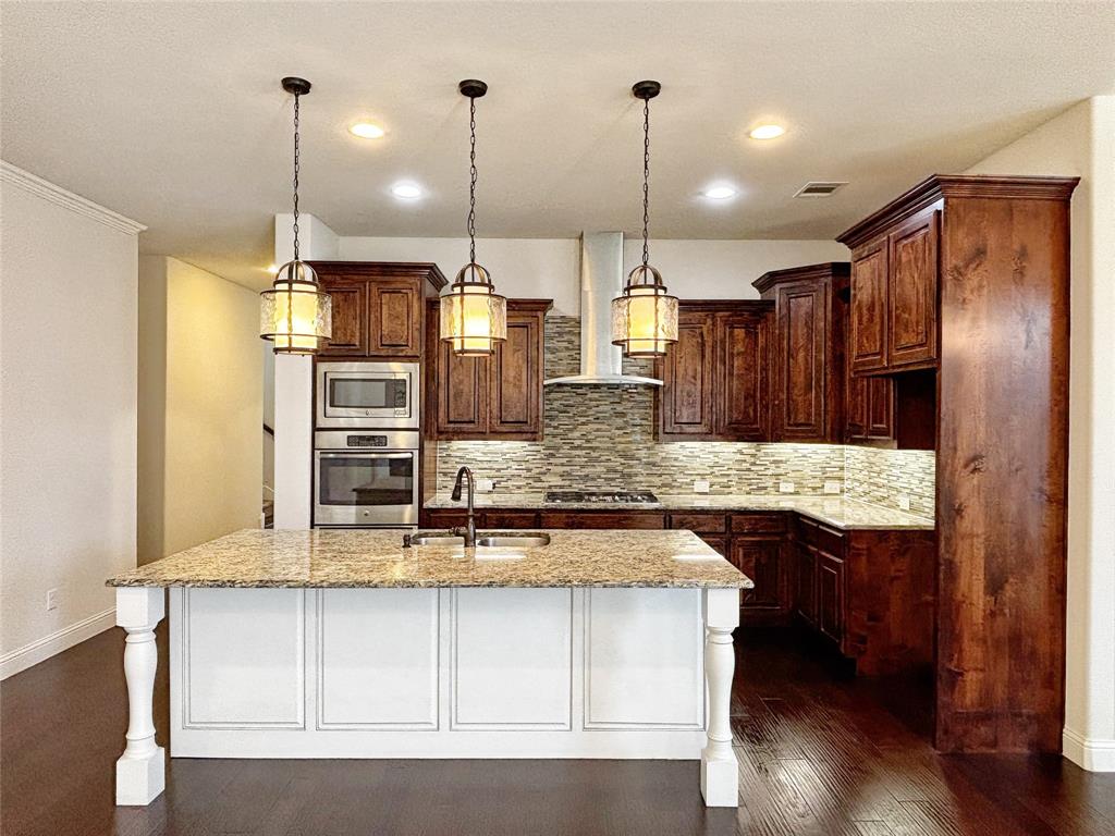 3037 Crestwater Ridge Keller, TX 76248 - Photo 12 of 25 a kitchen with kitchen island stainless steel appliances a sink a center island and a wooden floor
