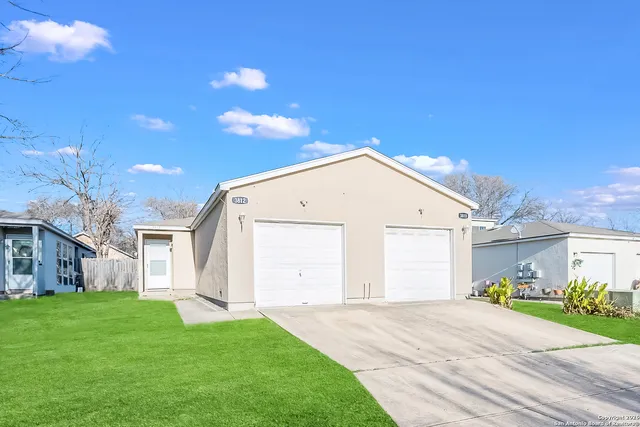 a view of a white house with a yard