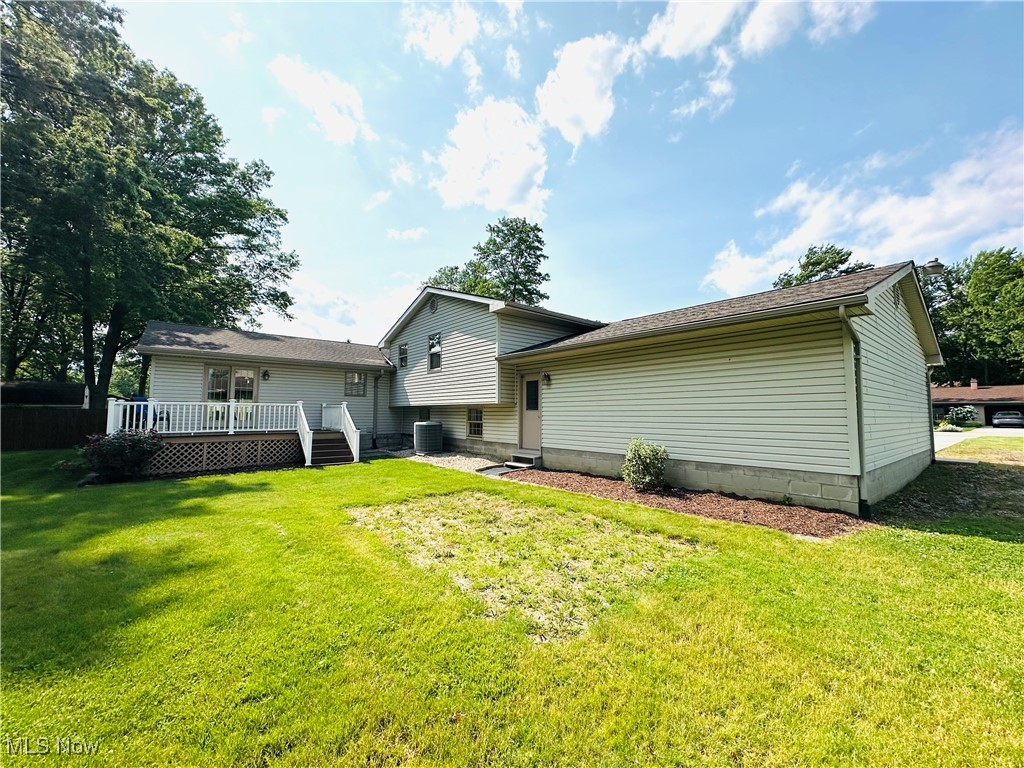 1684 Morris Street Mineral Ridge, OH 44440 - Photo 13 of 50 Back of house featuring a deck, a lawn, and central AC