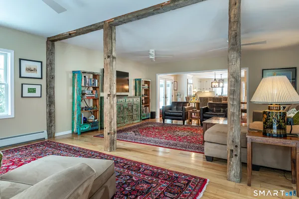 a spacious bedroom with a bed a table and painting on the wall