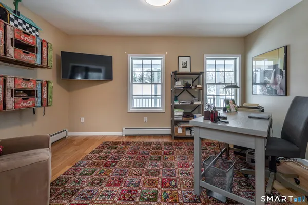 a view of a workspace with furniture and a window