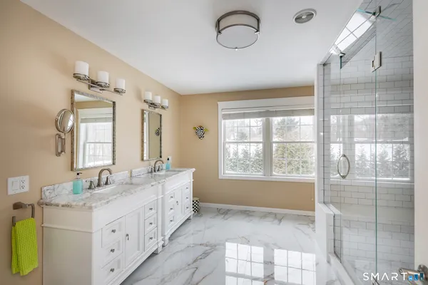a spacious bathroom with double vanity and a mirror