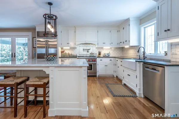 a kitchen with granite countertop white cabinets and white appliances