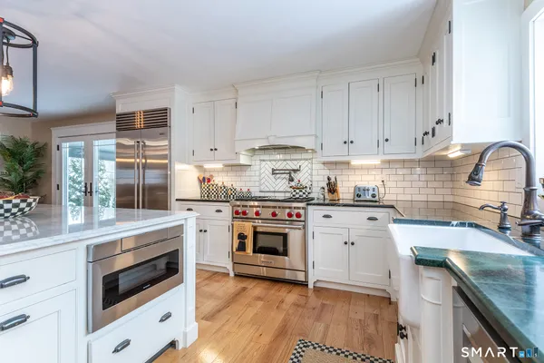 a kitchen with granite countertop cabinets stainless steel appliances and a sink