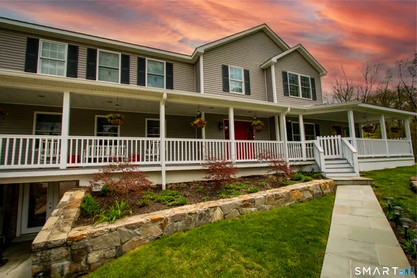 a view of a house with a small yard and wooden fence