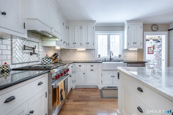 a kitchen with granite countertop a sink stove and cabinets