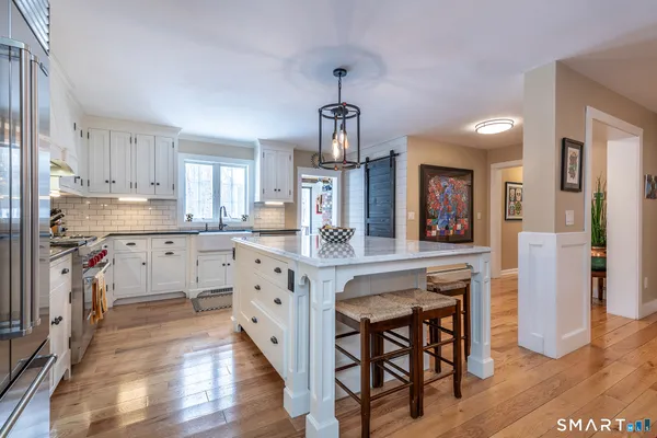 a kitchen with a table chairs refrigerator and cabinets