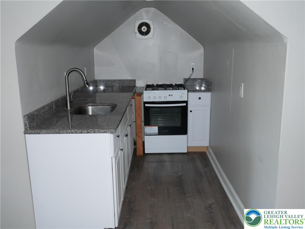 2110 Walnut Street, Unit E Allentown, PA 18104 - Photo 11 of 18 a kitchen with granite countertop a stove top oven and sink