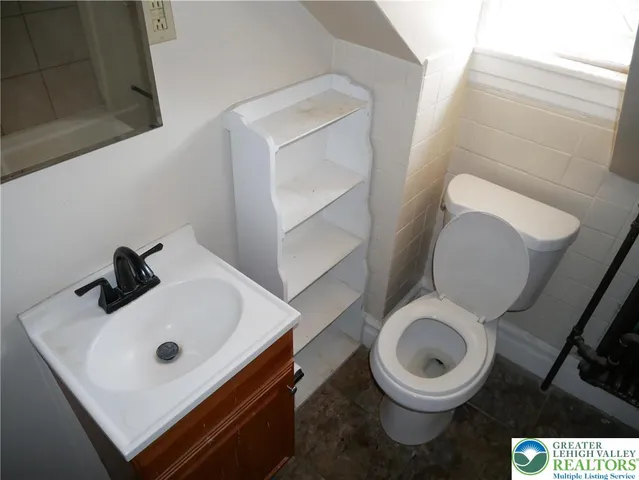 a white toilet sitting next to a bathroom sink
