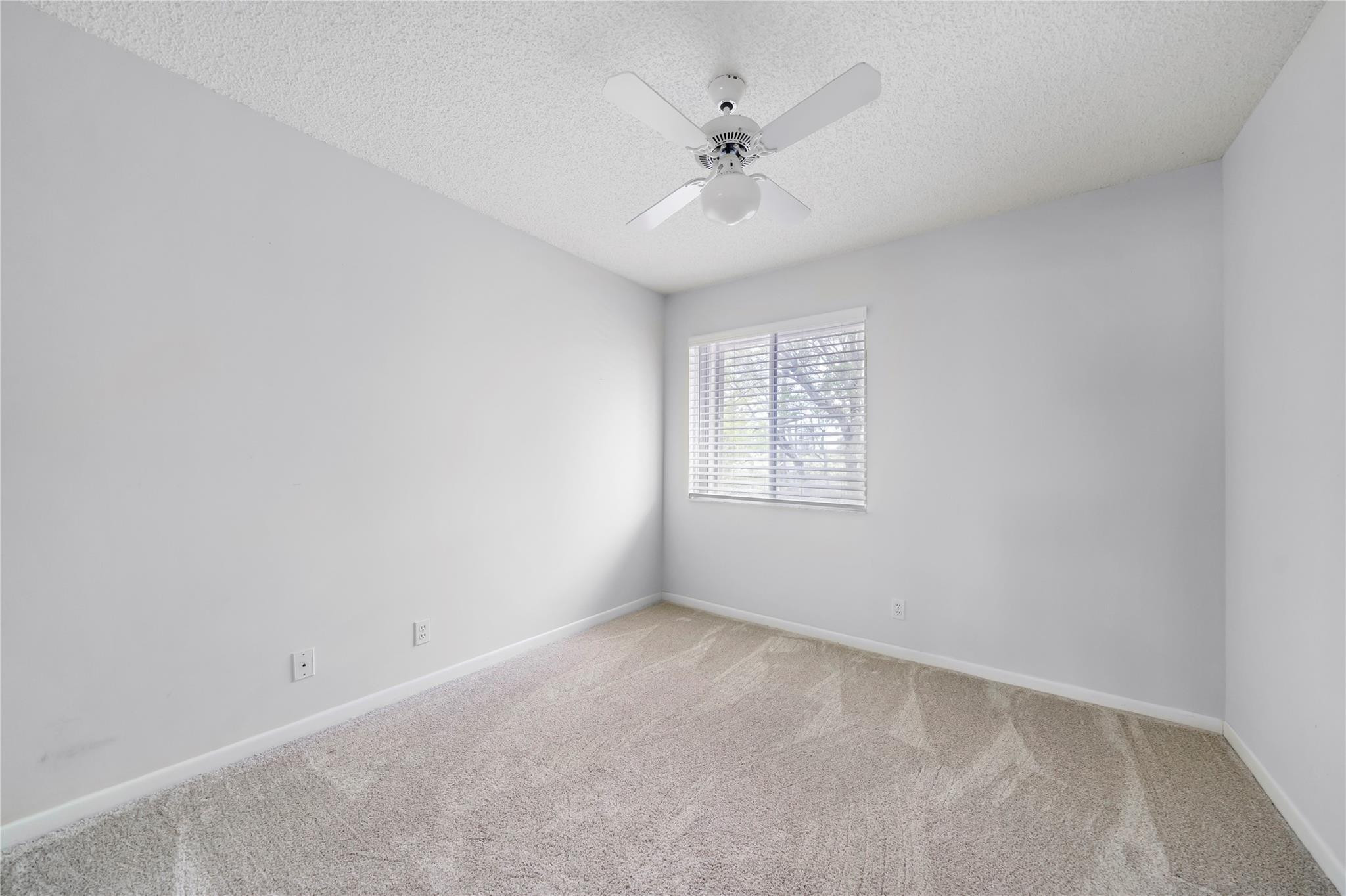 10423 Boca Springs Drive Boca Raton, FL 33428 - Photo 15 of 64 an empty room with windows and chandelier fan