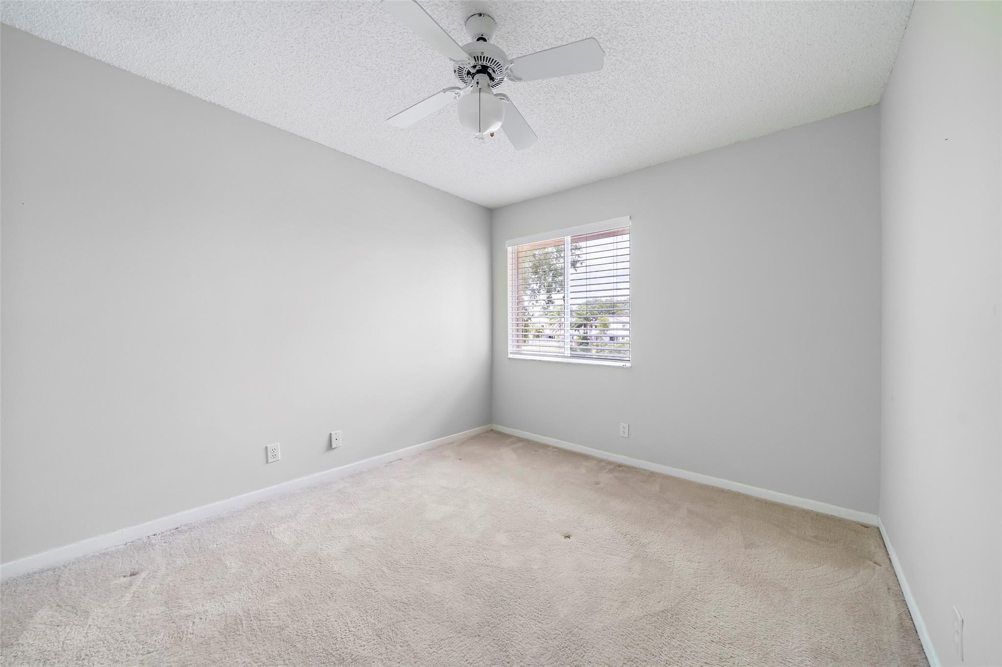 10423 Boca Springs Drive Boca Raton, FL 33428 - Photo 20 of 64 an empty room with windows and fan