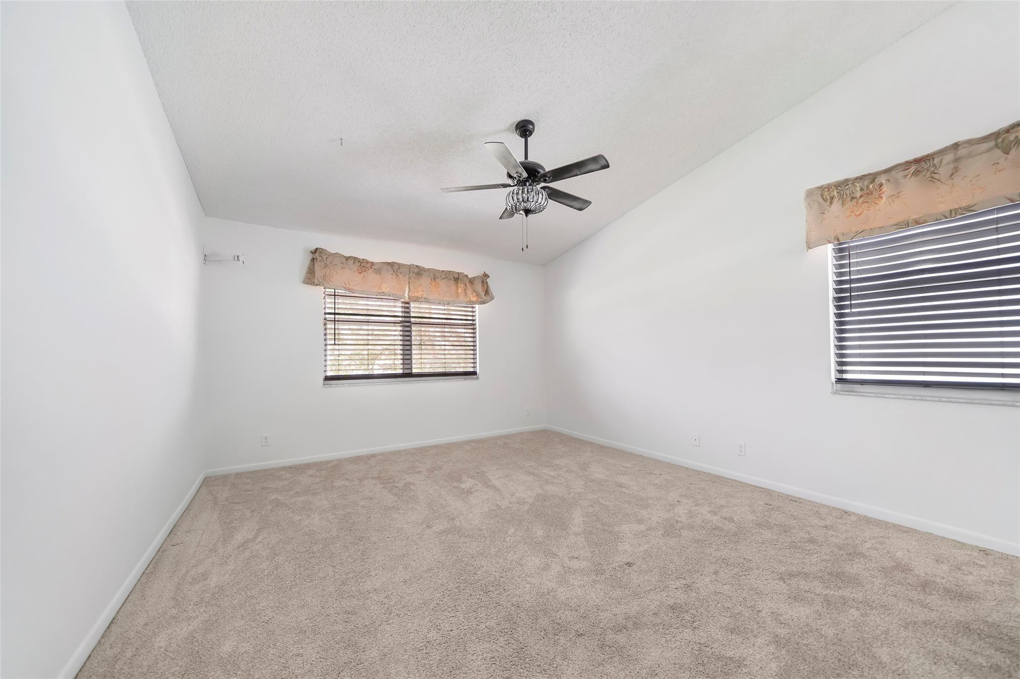 10423 Boca Springs Drive Boca Raton, FL 33428 - Photo 35 of 64 an empty room with windows and ceiling fan view