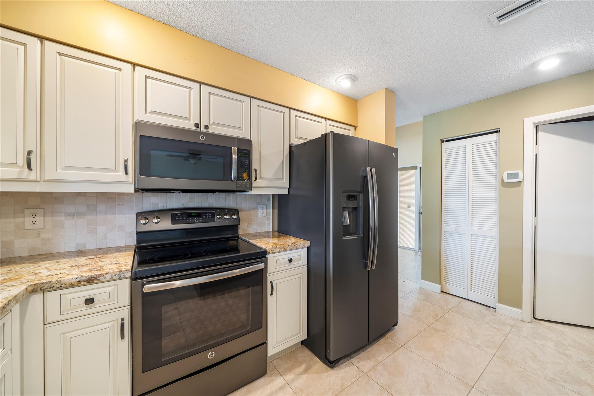 10423 Boca Springs Drive Boca Raton, FL 33428 - Photo 5 of 64 a kitchen with stainless steel appliances a refrigerator stove and microwave
