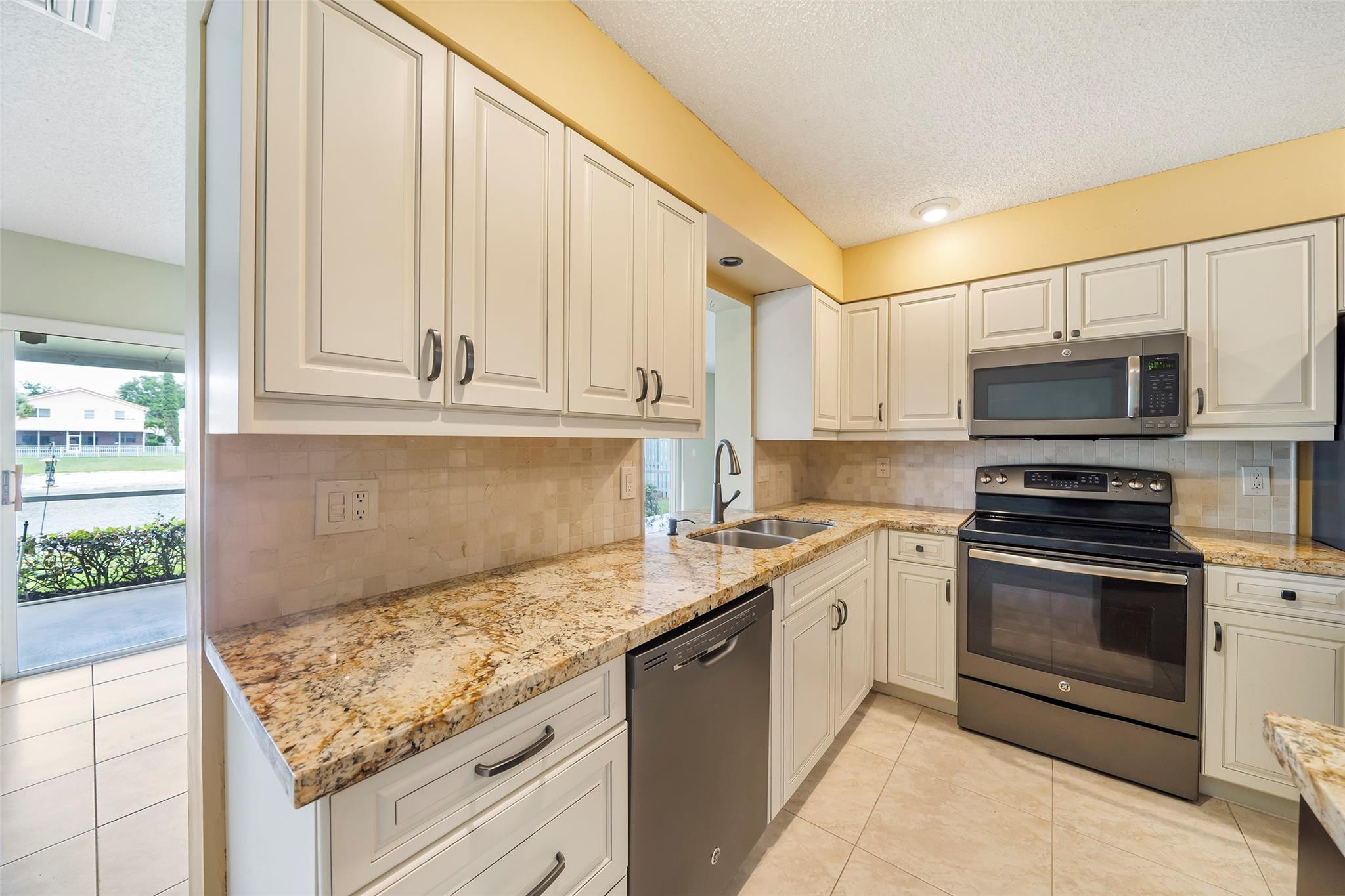 10423 Boca Springs Drive Boca Raton, FL 33428 - Photo 7 of 64 a kitchen with stainless steel appliances granite countertop a stove a sink and a microwave
