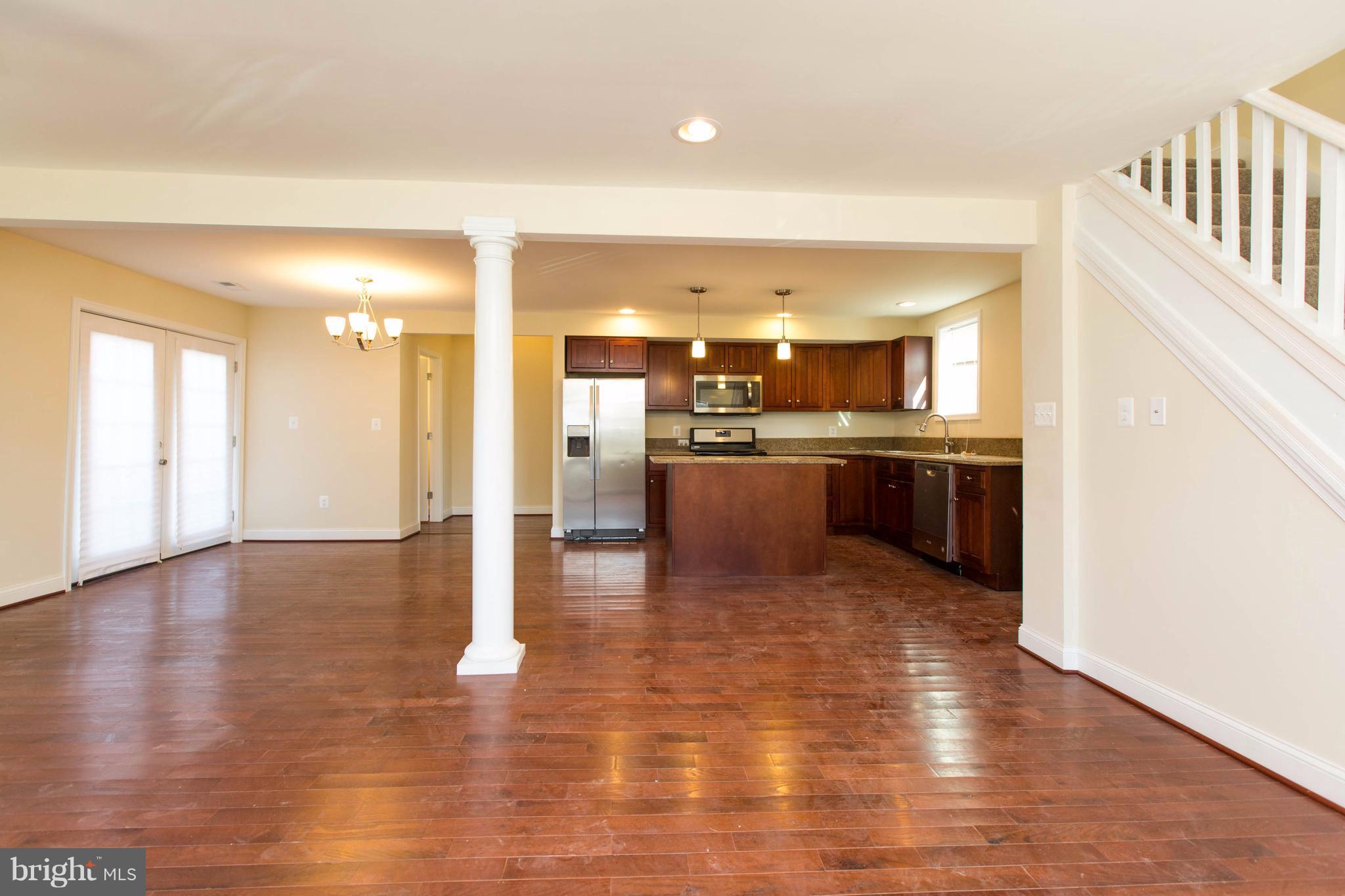 2016 Sulphur Spring Road Halethorpe, MD 21227 - Photo 3 of 30 a view of a kitchen with kitchen island a sink wooden floor and stainless steel appliances