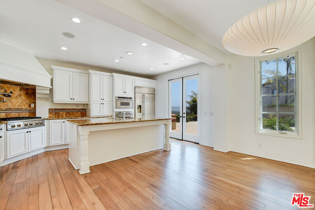 24 Still Water Newport Coast, CA 92657 - Photo 12 of 56 a large kitchen with cabinets wooden floor and stainless steel appliances