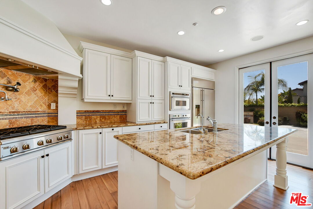 24 Still Water Newport Coast, CA 92657 - Photo 13 of 56 a kitchen with stainless steel appliances granite countertop a sink and cabinets