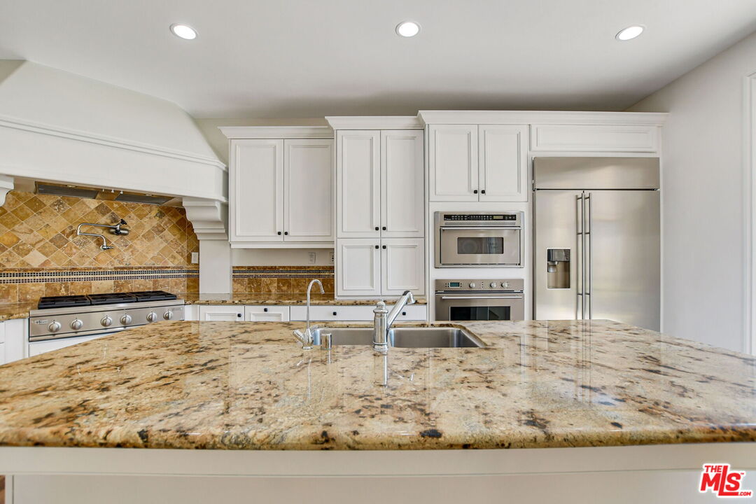 24 Still Water Newport Coast, CA 92657 - Photo 15 of 56 a kitchen with stainless steel appliances granite countertop a stove a sink and a refrigerator