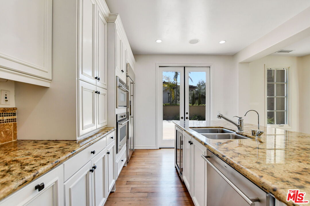 24 Still Water Newport Coast, CA 92657 - Photo 18 of 56 a kitchen with granite countertop a sink and a stove