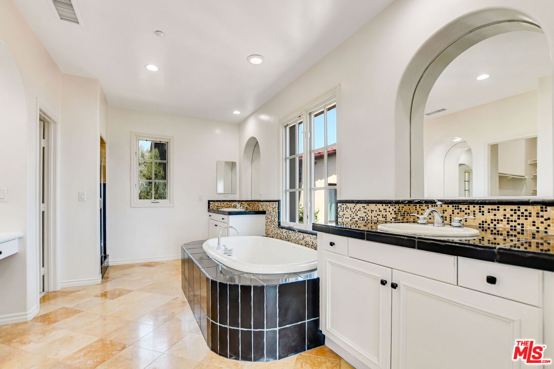 24 Still Water Newport Coast, CA 92657 - Photo 35 of 56 a bathroom with a sink a mirror and a bathtub