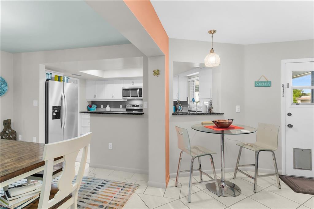 1337 Wisconsin Drive Naples, FL 34103 - Photo 14 of 35 a kitchen with stainless steel appliances kitchen island granite countertop a refrigerator and a stove top oven