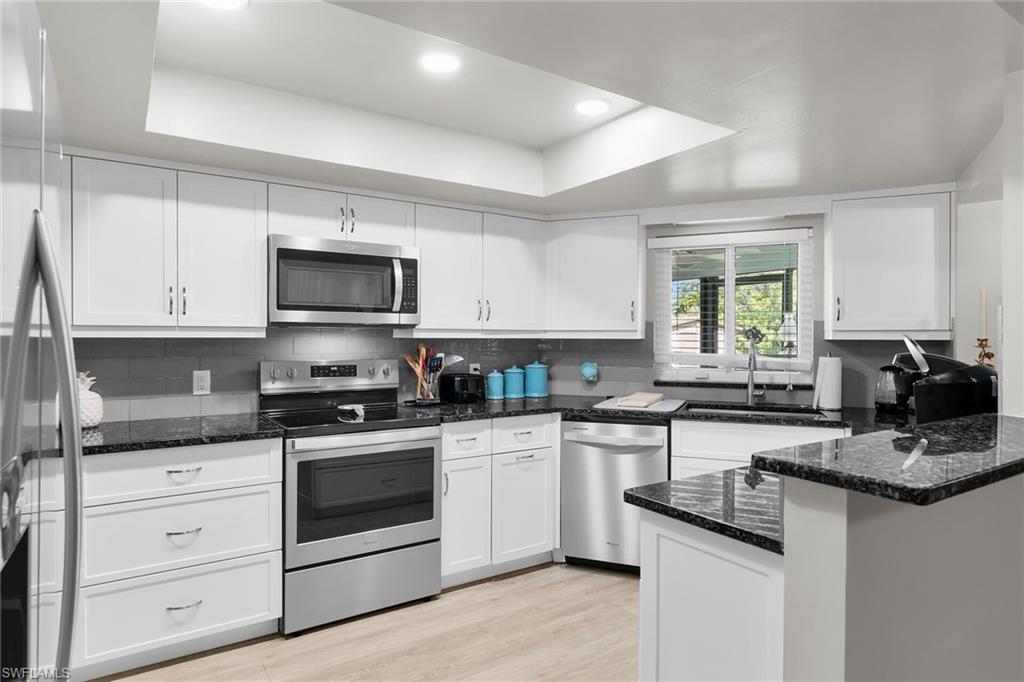 1337 Wisconsin Drive Naples, FL 34103 - Photo 9 of 35 a kitchen with a sink stove top oven and cabinets