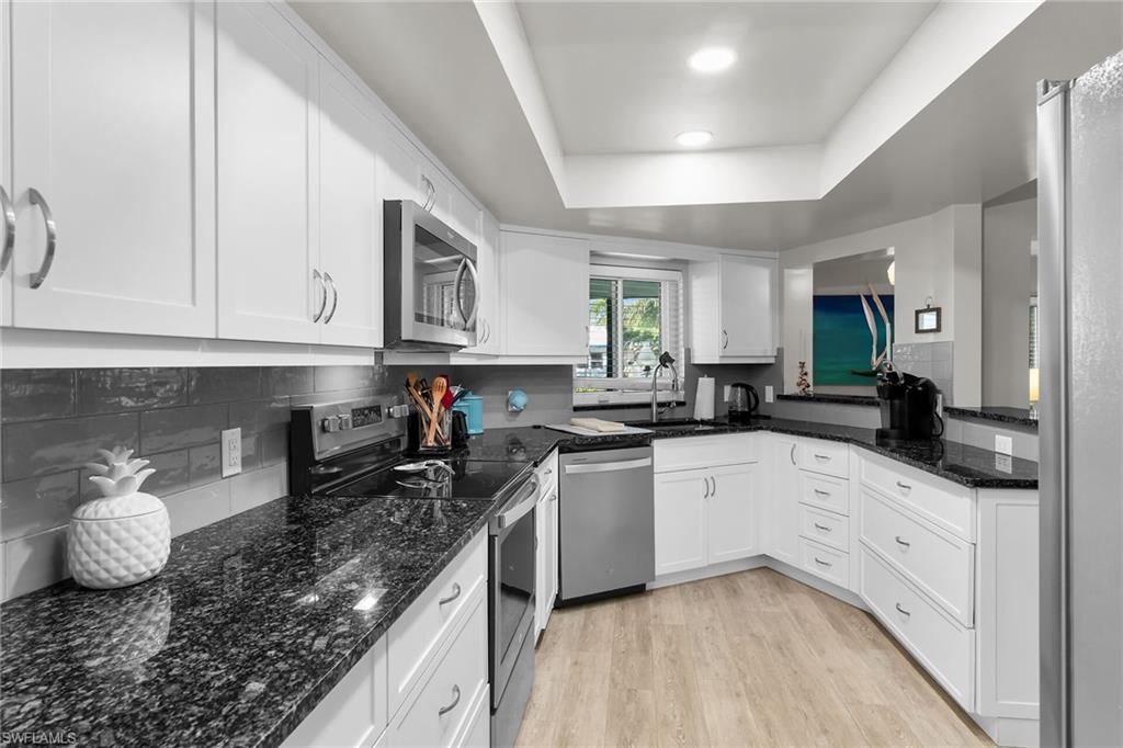 1337 Wisconsin Drive Naples, FL 34103 - Photo 10 of 35 a kitchen with granite countertop a sink and cabinets