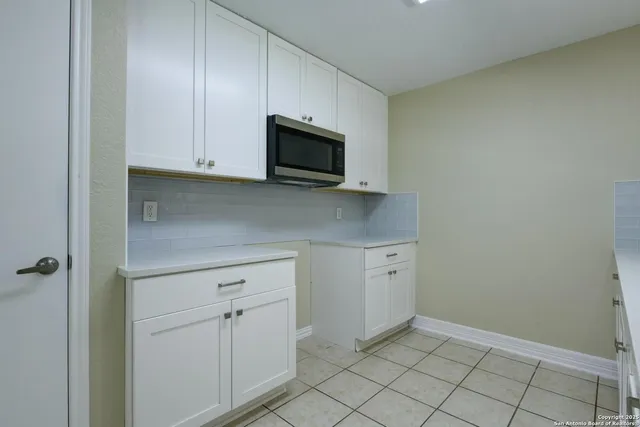 a kitchen with white cabinets stainless steel appliances and sink