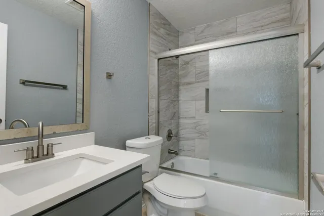 a bathroom with a sink mirror toilet and shower