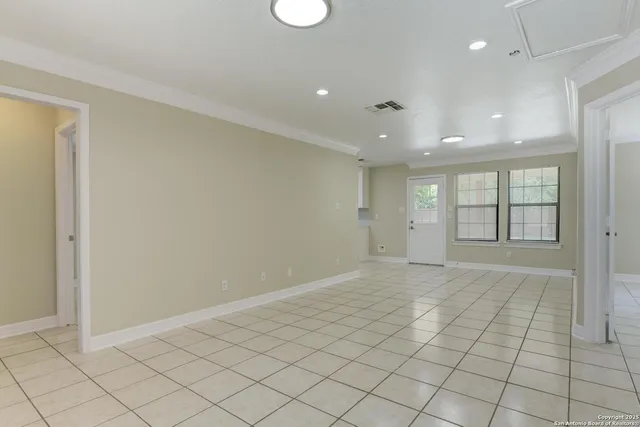 an empty room with windows and painted walls