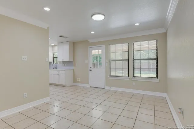 a view of an empty room with window and cabinet